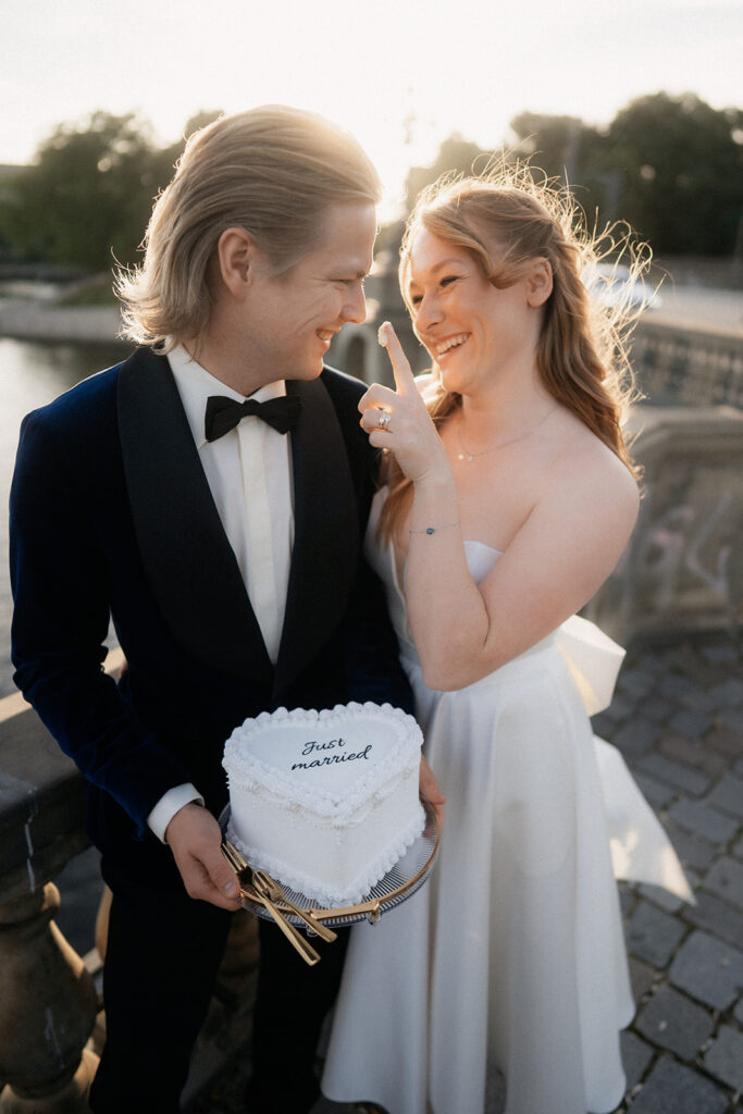 Braut gibt Bräutigam die Hochzeitstorte zu probieren während der Bräutigam die Torte hält