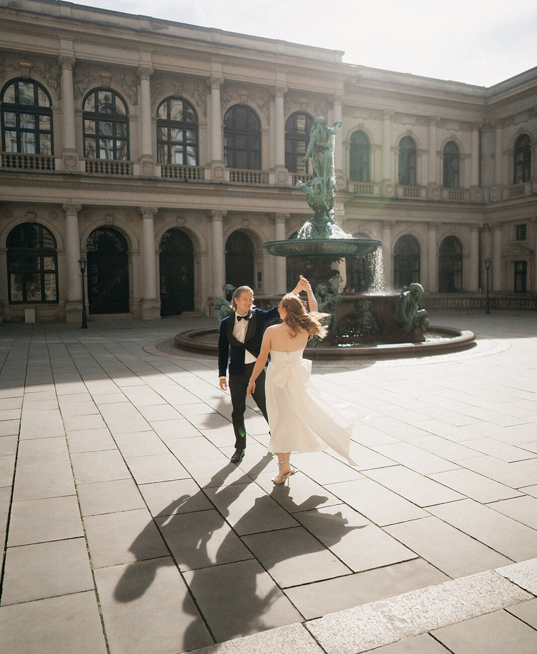 Brautpaar tanzt Hochzeitstanz vor Brunnen